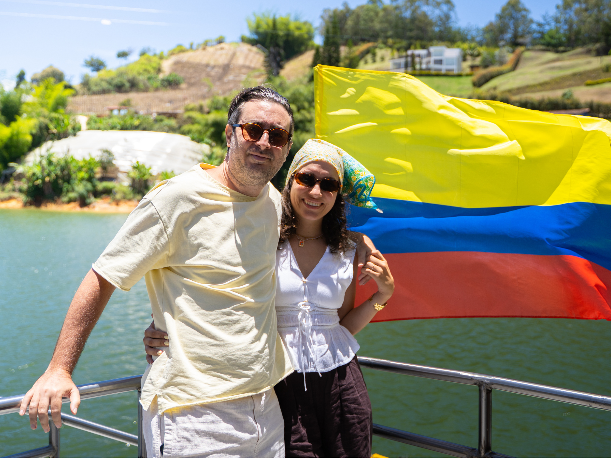 Pareja en el barco por el embalse de Guatapé, con la bandera de Colombia