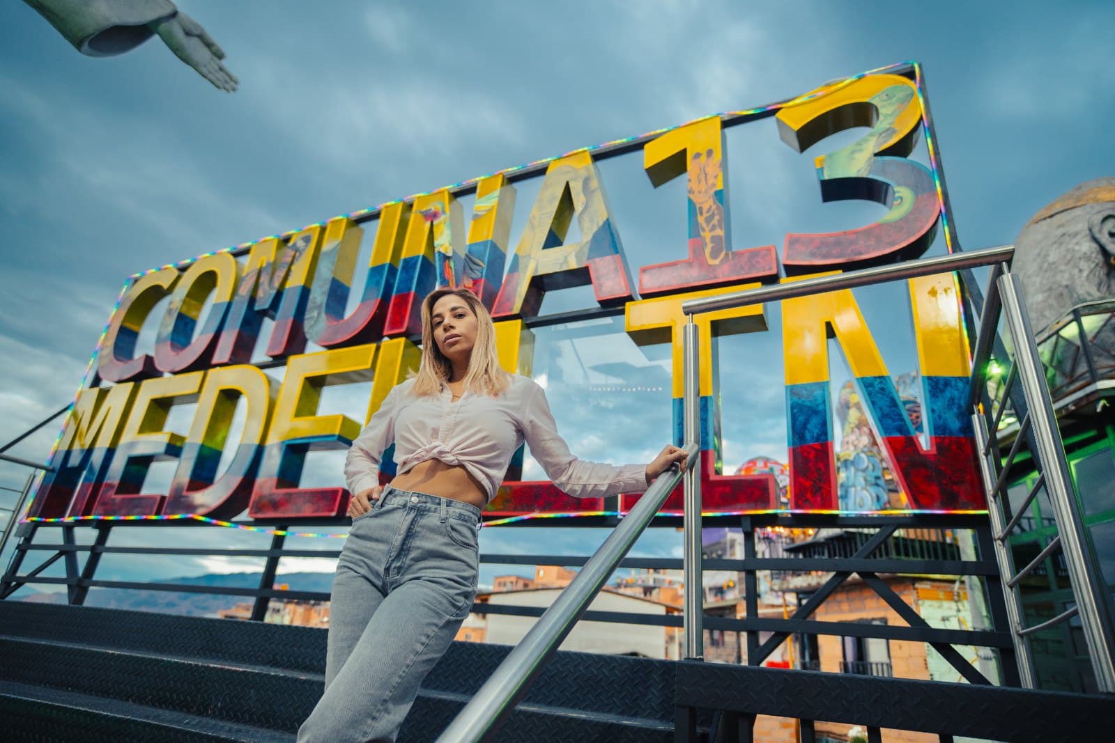 Traveler in front of the colorful "Comuna 13 Medellín" sign