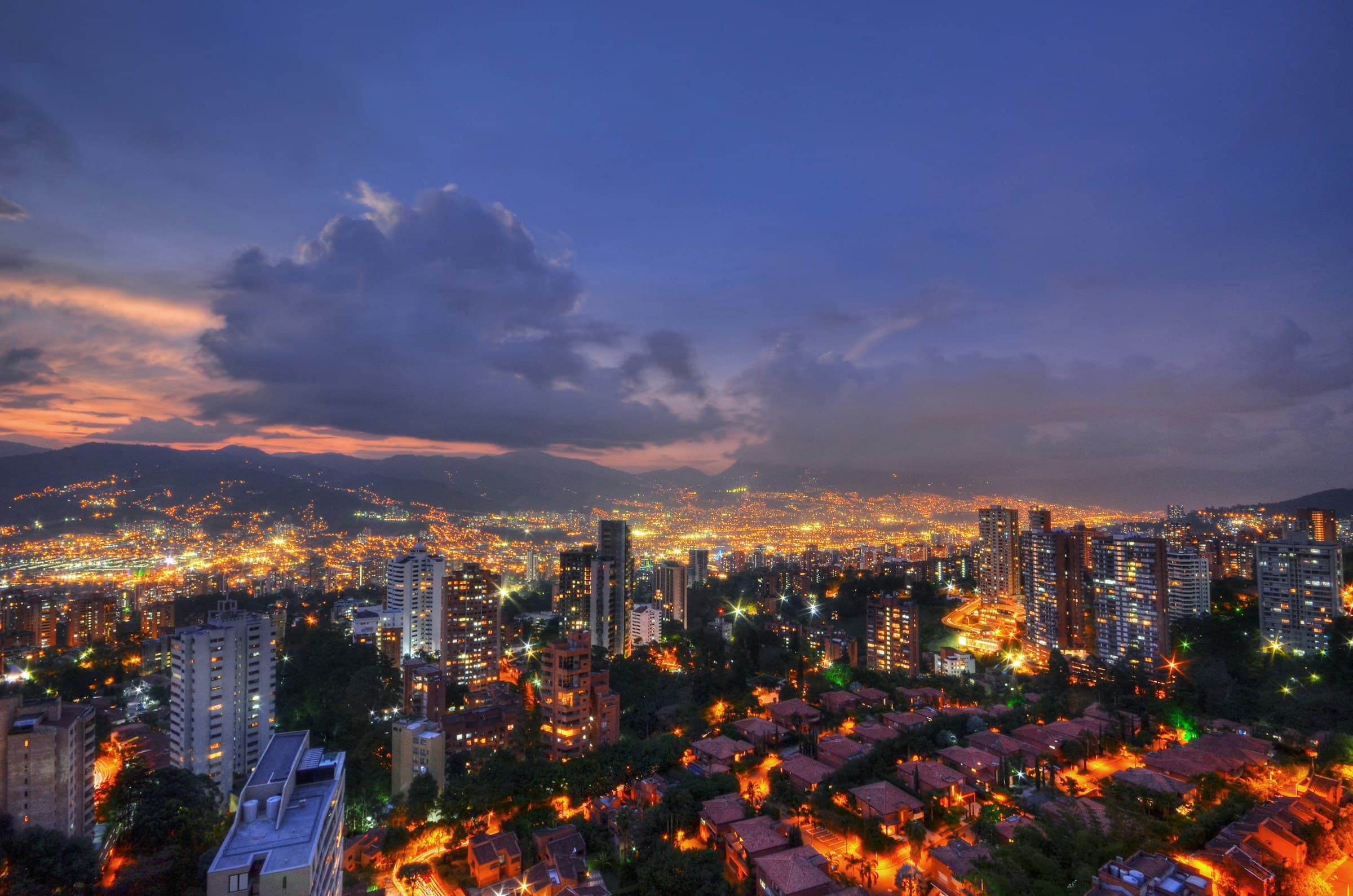 Medellín at dusk, with the city lights on