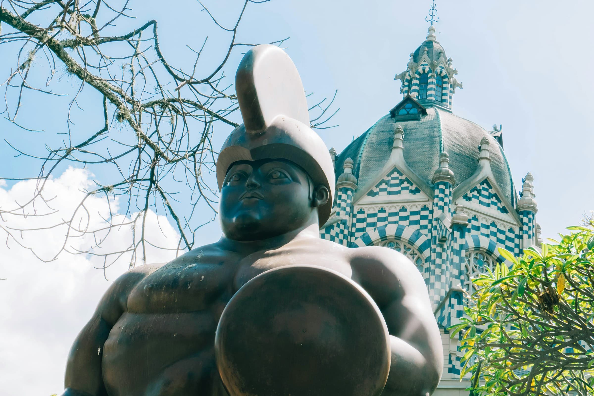Fernando Botero sculpture in Plaza Botero, with the dome of the Palacio de la Cultura behind